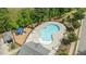 Overhead view of a large community pool with plentiful lounge chairs, a playground, and attractive landscaping at 4718 Sleepy Falls Run, Knightdale, NC 27545
