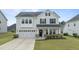 Charming two-story home with a well-manicured lawn, black shutters, and an attached two-car garage at 4718 Sleepy Falls Run, Knightdale, NC 27545