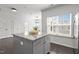 Kitchen island with gray cabinets, granite countertop, and a view into the adjacent dining area at 4718 Sleepy Falls Run, Knightdale, NC 27545