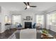 Stylish living room features modern ceiling fan, large windows, dark hardwood floors, and neutral decor at 4718 Sleepy Falls Run, Knightdale, NC 27545