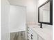 Modern bathroom vanity with a sleek countertop, black hardware, and open doorway to the next room at 50 Rosewood Ln, Youngsville, NC 27596