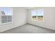 Bright bedroom with carpet and large windows looking out to trees and houses at 50 Rosewood Ln, Youngsville, NC 27596