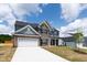 Charming two-story home with brick, gray siding, a white garage door, and manicured landscaping at 50 Rosewood Ln, Youngsville, NC 27596
