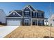 Two-story home featuring gray siding, a white garage door and black shutters under a clear blue sky at 50 Rosewood Ln, Youngsville, NC 27596