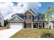 New two-story home featuring brick and gray siding, a two-car garage, and a well-manicured front lawn at 50 Rosewood Ln, Youngsville, NC 27596