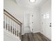 Bright foyer featuring hardwood floors, a staircase with white railings, and an open doorway at 50 Rosewood Ln, Youngsville, NC 27596