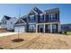 Inviting two-story home with blue siding, shutters, white garage door, and covered front porch at 50 Rosewood Ln, Youngsville, NC 27596