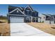 Charming home with a wide driveway, two-car garage, and blue exterior under a bright sky at 50 Rosewood Ln, Youngsville, NC 27596
