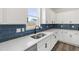 Close-up of modern kitchen with stainless steel sink, white cabinets, and dark backsplash near a window at 50 Rosewood Ln, Youngsville, NC 27596