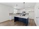 Modern kitchen featuring white cabinets, a dark kitchen island, and stainless appliances at 50 Rosewood Ln, Youngsville, NC 27596