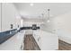 Stylish kitchen boasts white cabinets, quartz countertops, and a large island with pendant lighting at 50 Rosewood Ln, Youngsville, NC 27596