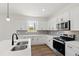 Well-lit kitchen featuring white cabinets, stainless steel appliances, and modern fixtures at 50 Rosewood Ln, Youngsville, NC 27596