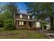 Charming two-story brick home with a welcoming front porch and mature trees at 500 Cokey Rd, Rocky Mount, NC 27801