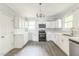 Bright kitchen featuring white cabinets, modern appliances, stylish lighting, and wood-look flooring at 500 Cokey Rd, Rocky Mount, NC 27801