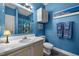 Bright blue bathroom with a vanity, toilet, and shower with decorative curtain at 5013 W Pool Rd, Rougemont, NC 27572