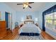 Serene bedroom featuring hardwood floors, a ceiling fan, a large window, and calming blue walls at 5013 W Pool Rd, Rougemont, NC 27572