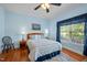 Comfortable bedroom features hardwood floors, a ceiling fan, a large window, and calming blue walls at 5013 W Pool Rd, Rougemont, NC 27572