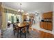 Open dining area showcasing wooden table, updated lighting and views of living space at 5013 W Pool Rd, Rougemont, NC 27572