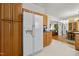 Spacious kitchen with wood cabinets and white appliances, flowing into dining area at 5013 W Pool Rd, Rougemont, NC 27572