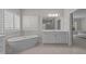 Bright bathroom featuring double vanities, a soaking tub and plantation shutters at 5145 Landguard Dr, Raleigh, NC 27613