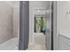 Well-lit bathroom featuring a shower/tub combo, neutral-toned tile, and a glimpse into a bedroom through an open door at 5145 Landguard Dr, Raleigh, NC 27613
