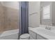 Bathroom with shower-tub combo, tiled walls, and single sink vanity at 5145 Landguard Dr, Raleigh, NC 27613