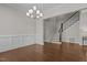 Open dining space with wainscoting detail near stairway, hardwood floors and chandelier at 5145 Landguard Dr, Raleigh, NC 27613