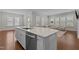 Open kitchen island with bar seating, stainless steel appliances, and a view into the adjacent living room at 5145 Landguard Dr, Raleigh, NC 27613