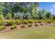 Landscaped yard features lush greenery, trees, and mulch, enhancing the property's natural beauty at 5145 Landguard Dr, Raleigh, NC 27613