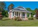 Quaint home with a metal roof, brick chimney, and a welcoming porch with white columns and green lawn at 5299 Momeyer Way, Nashville, NC 27856