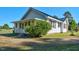 View of a charming home featuring a covered porch, white siding, dark shutters, and well-maintained landscaping at 5299 Momeyer Way, Nashville, NC 27856