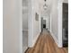 Inviting hallway featuring hardwood floors, neutral paint, and a modern light fixture at 5299 Momeyer Way, Nashville, NC 27856
