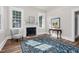 Bright living room featuring a fireplace, large windows, and stylish decor with a patterned area rug at 5299 Momeyer Way, Nashville, NC 27856