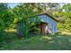 Exterior view of rustic barn shed nestled among trees, showcasing its weathered facade and country charm at 5299 Momeyer Way, Nashville, NC 27856