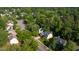 Aerial view of a charming yellow two-story home nestled among lush green trees in a quiet neighborhood at 5417 Harrington Grove Dr, Raleigh, NC 27613