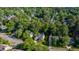 Aerial view of a yellow house surrounded by lush trees and other beautiful homes in a serene neighborhood at 5417 Harrington Grove Dr, Raleigh, NC 27613