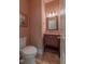 Compact bathroom features a wood vanity with a marble countertop and tiled flooring at 5417 Harrington Grove Dr, Raleigh, NC 27613