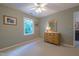 Bright bedroom featuring a window, beige carpet, and an antique dresser with mirror at 5417 Harrington Grove Dr, Raleigh, NC 27613