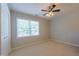 Minimalist bedroom features neutral carpet, a large window, and a ceiling fan at 5417 Harrington Grove Dr, Raleigh, NC 27613