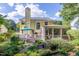 A bright yellow home featuring a deck, a screened porch, and lush landscaping at 5417 Harrington Grove Dr, Raleigh, NC 27613