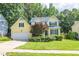 Beautiful two-story home with a manicured lawn, complemented by colorful flowerbeds and mature trees at 5417 Harrington Grove Dr, Raleigh, NC 27613