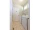 Practical laundry room featuring white appliances, shelving, and ample natural light from the window at 5417 Harrington Grove Dr, Raleigh, NC 27613