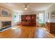 Cozy living room featuring hardwood floors, a fireplace, and a custom built-in shelving unit at 5417 Harrington Grove Dr, Raleigh, NC 27613