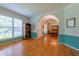 Bright, open living room with hardwood floors, large windows, and archway to dining area at 5417 Harrington Grove Dr, Raleigh, NC 27613