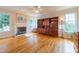 Living room with a fireplace, large windows for natural light, and beautiful hardwood floors at 5417 Harrington Grove Dr, Raleigh, NC 27613