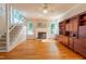 Sunlit living room with hardwood floors, fireplace, a staircase, and built-in shelving at 5417 Harrington Grove Dr, Raleigh, NC 27613