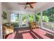 Inviting screened porch with wicker furniture, red flooring, and views of the backyard at 5417 Harrington Grove Dr, Raleigh, NC 27613