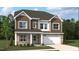 Charming two-story home featuring a stone facade, brown siding, white trim, and an attached two car garage at 556 Jocund St # 13, Rolesville, NC 27571