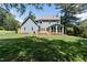 Expansive backyard featuring lush green grass, a deck, and a charming screened-in porch at 5812 N Beaver Ln, Raleigh, NC 27604