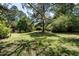 Backyard with large shade trees and plush green grass at 5812 N Beaver Ln, Raleigh, NC 27604